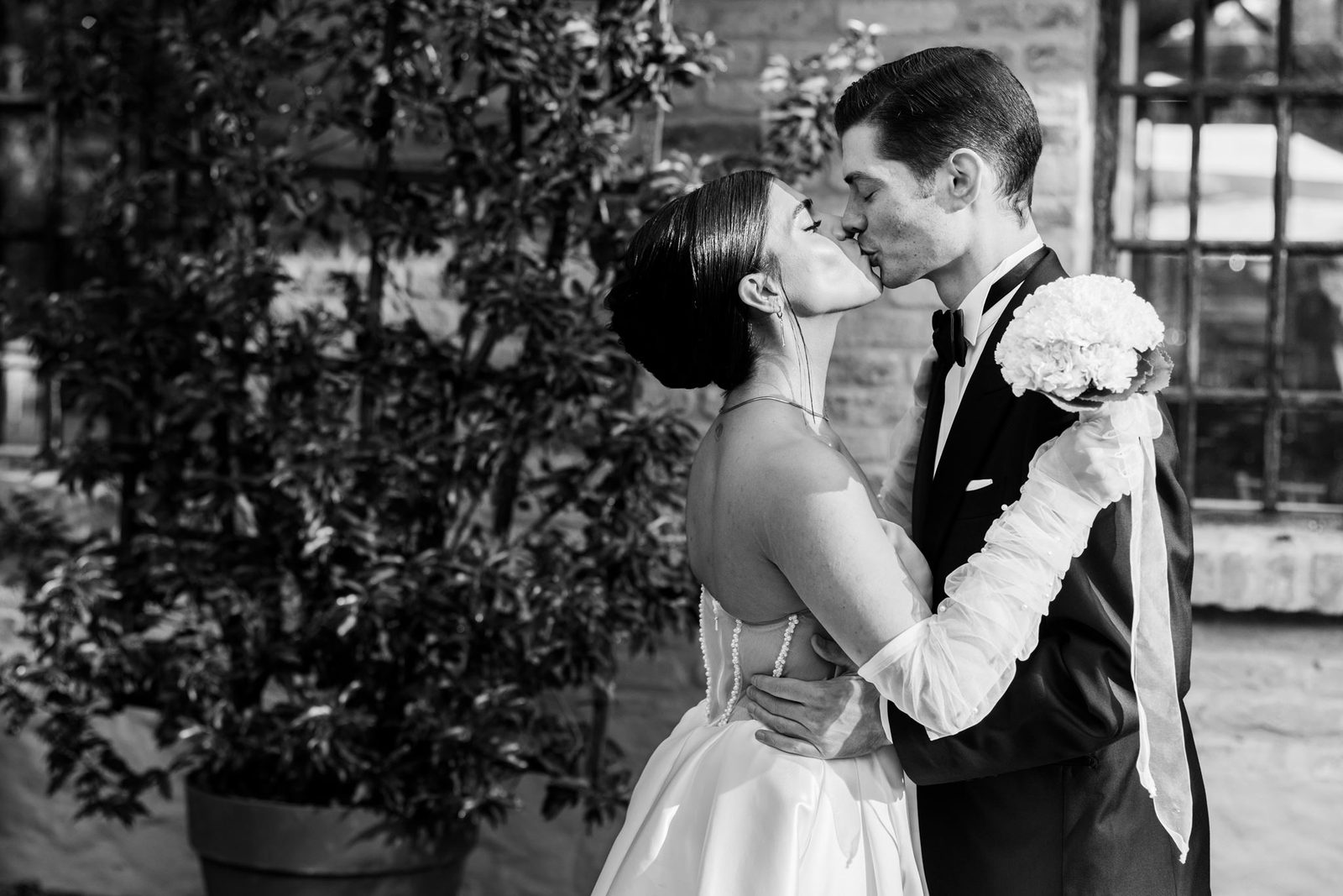 Persian bride and groom kissing — editorial black and white wedding portrait