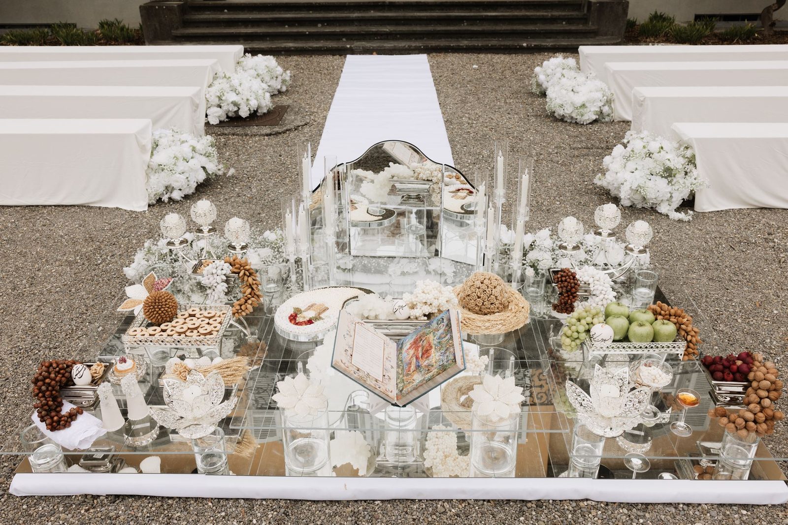 Sofreh Aghd — Persian wedding ceremonial spread with antique mirror, gold candelabras, decorated eggs, walnuts, pomegranate and symbolic elements