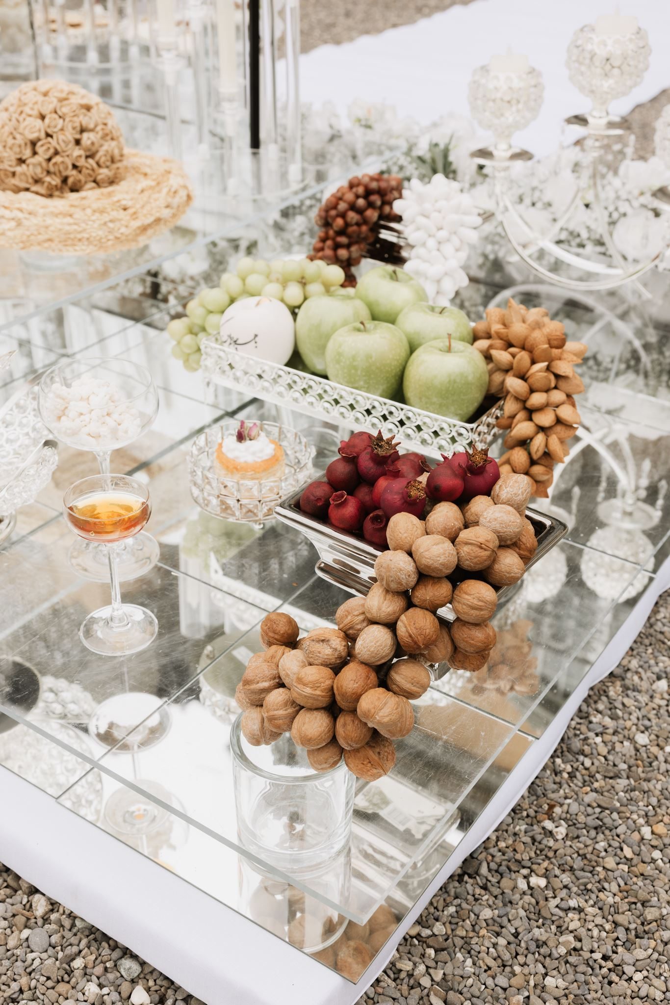 Sofreh Aghd ceremonial detail — walnuts, green apples, pomegranates and gold-rimmed crystal